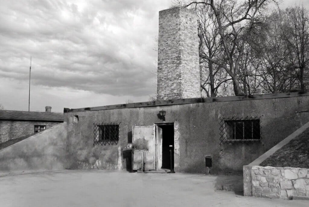 Black and white photograph of the crematorium building and chimney at Auschwitz I.