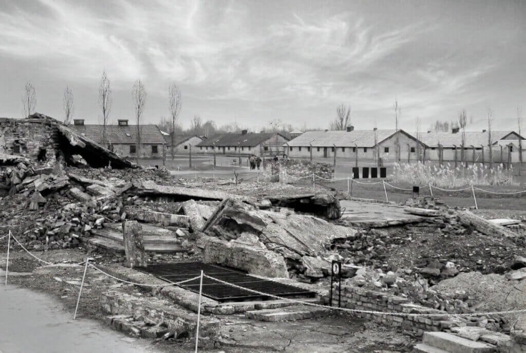 Black and white photograph of the destroyed crematorium ruins at Auschwitz-Birkenau.
