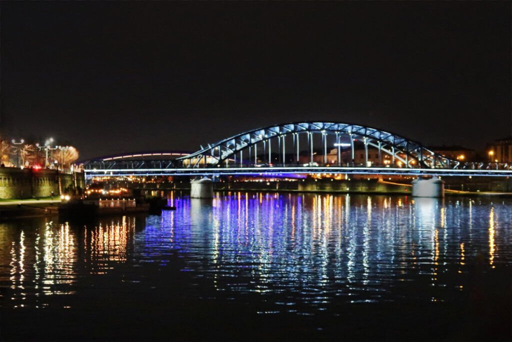Father Bernatek Footbridge at night over the Vistula River in Krakow.